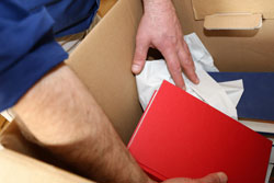 man putting books in a box